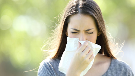 Girl sneezing and blowing in a wipe