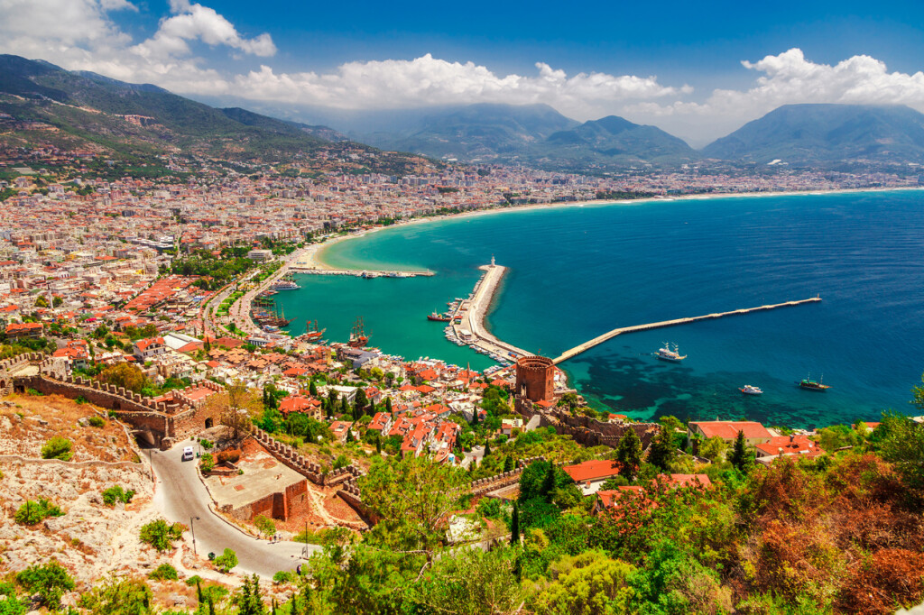Landscape with marina and Kizil Kule tower in Alanya peninsula, Antalya district, Turkey, Asia. Famous tourist destination with high mountains. Part of ancient old Castle. Summer bright day