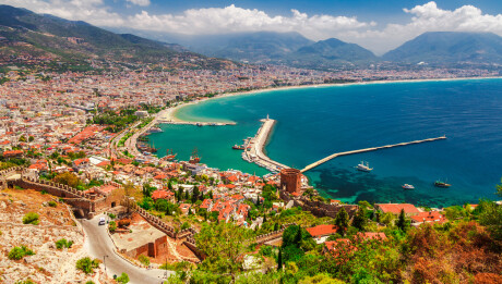 Landscape with marina and Kizil Kule tower in Alanya peninsula, Antalya district, Turkey, Asia. Famous tourist destination with high mountains. Part of ancient old Castle. Summer bright day