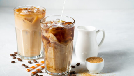 Ice,Coffee,In,A,Tall,Glass,With,Cream,Poured,Over